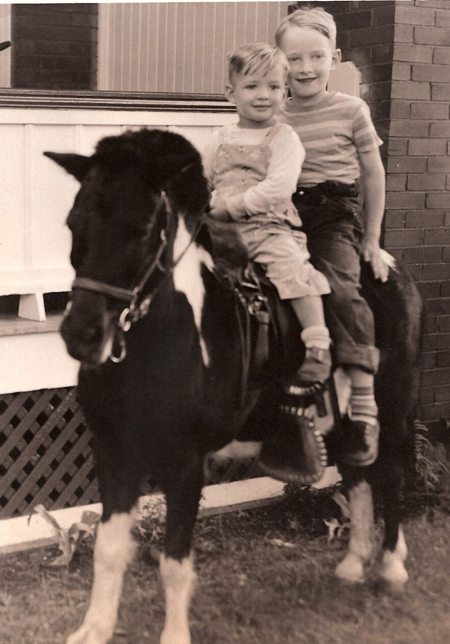 James sitting behind his brother Paul on a pony.